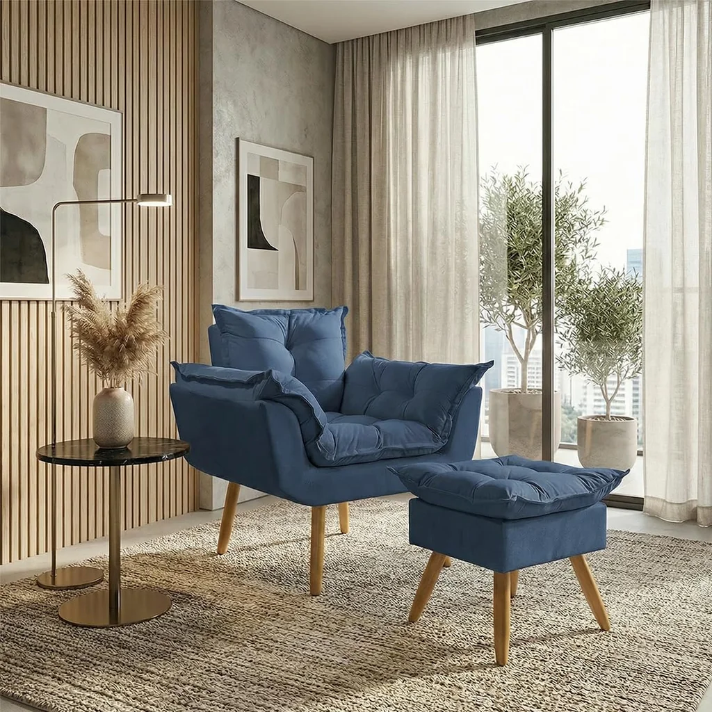 Poltrona decorativa em suede azul marinho com puff a conjunto e pés de madeira, em sala de estar moderna