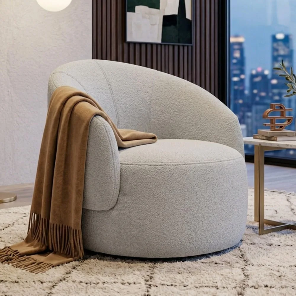 Poltrona decorativa orgânica Saara em bouclê bege, formato giratório arredondado, em ambiente minimalista.