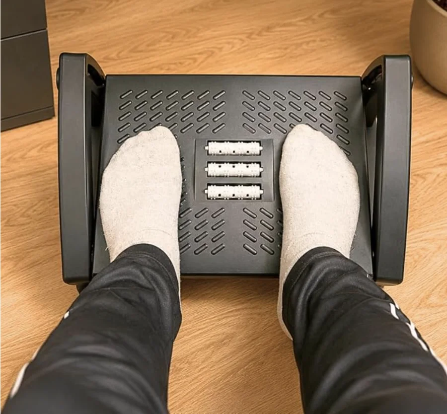 Apoio de pés ergonômico QBQ com rolos massageadores usado sob a mesa