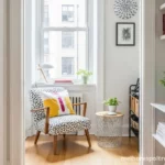 A melhor poltrona pequena para apartamento, posicionada em um canto charmoso perto da janela, otimizando o espaço.