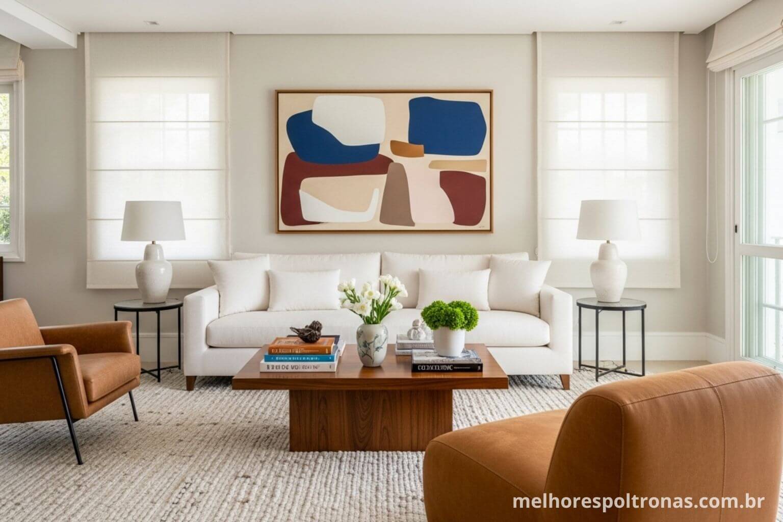 Sala de estar elegante mostrando como combinar um sofá branco com poltronas de couro caramelo.
