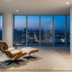 A melhor poltrona de luxo, um modelo de design icônico, em um apartamento com vista para a cidade, representando um investimento em estilo.