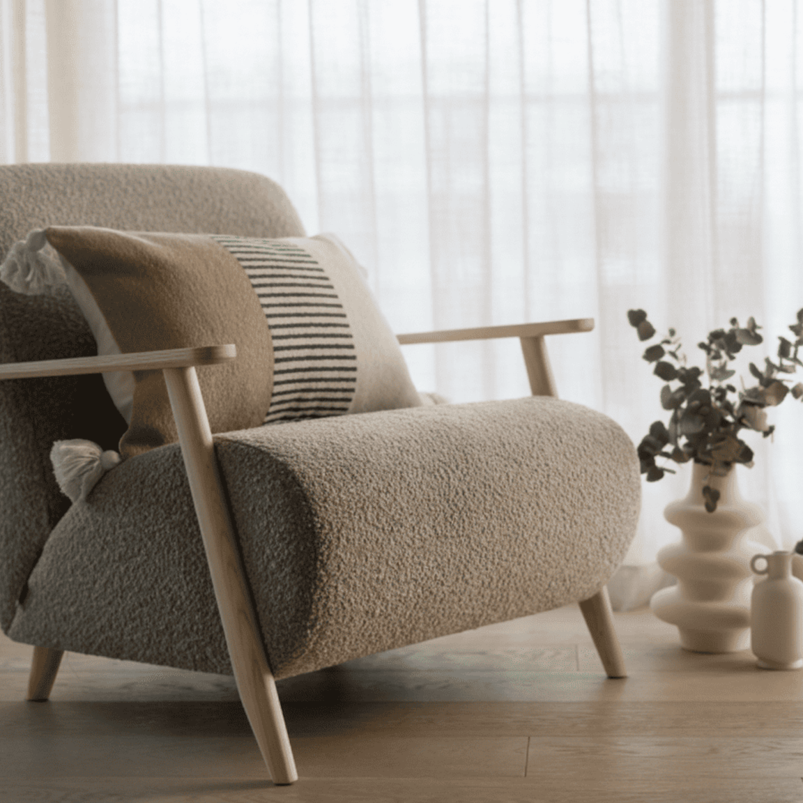 Poltrona decorativa elegante com design moderno, centralizada em sala de estar sofisticada e iluminada por luz natural.