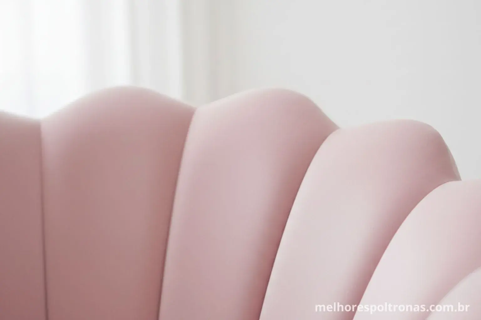 Close-up nos detalhes de uma poltrona Pétala de veludo rosa, mostrando seu design inspirado em uma flor.