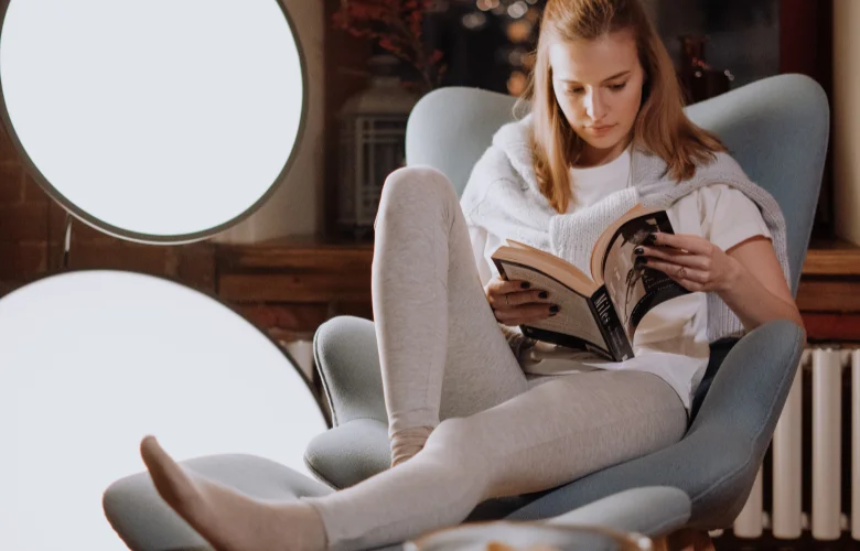 Poltrona ergonômica ideal para leitura 2026 em ambiente minimalista acolhedor com livro aberto, luz natural e design confortável para sessões prolongadas sem dores na coluna